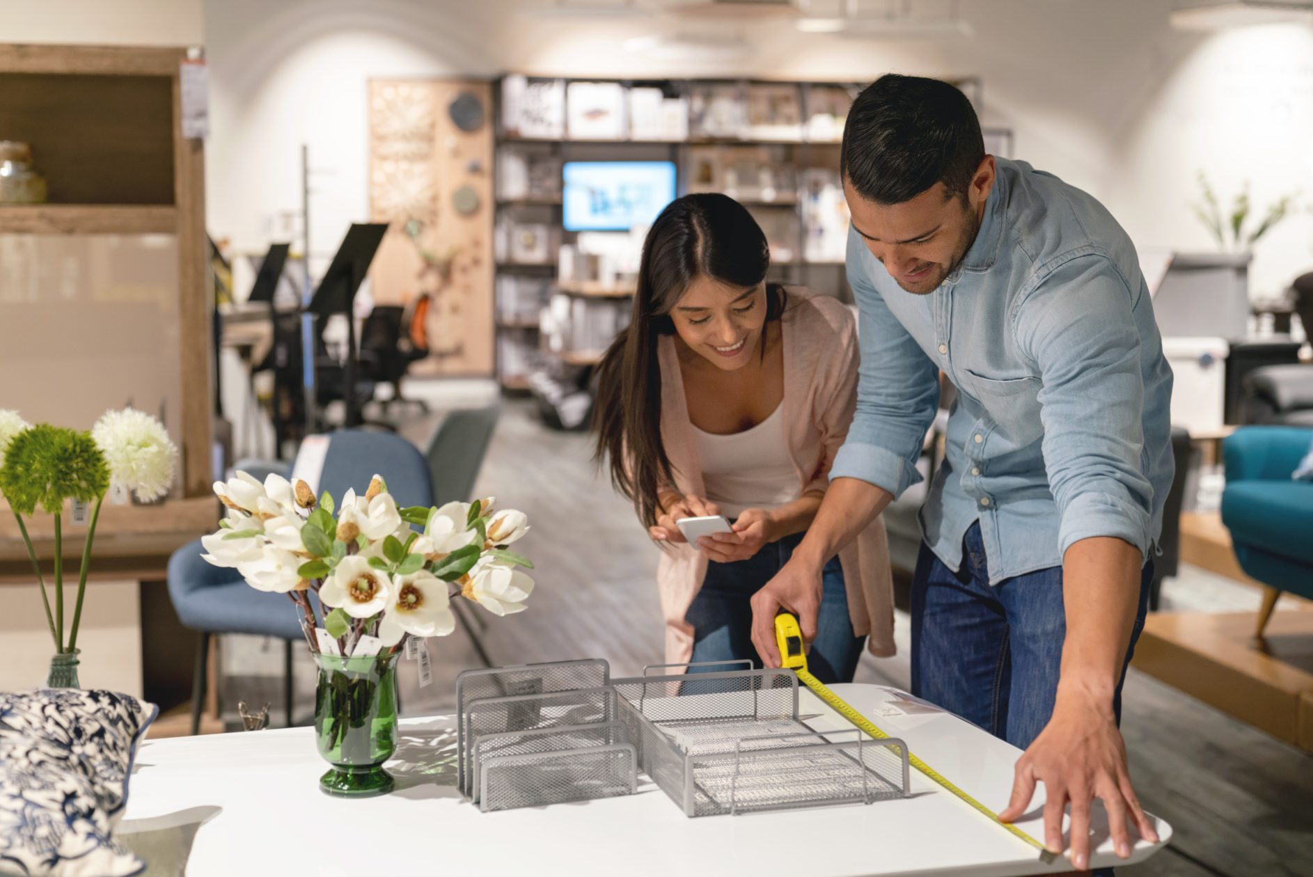 Couple measuring a table in a furniture store