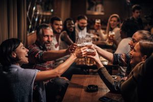 A group of friends laughing and enjoying drinks together at a casual bar.